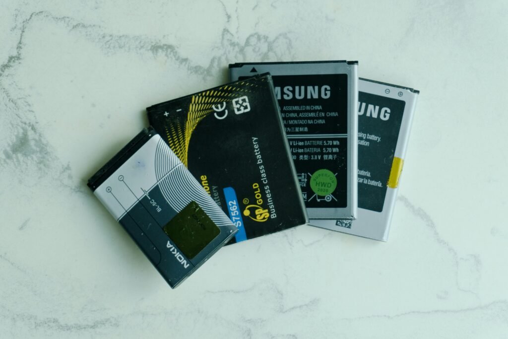 Several old mobile phone batteries on a white surface