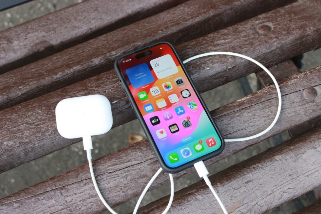 a cell phone hooked up to a charger on a bench